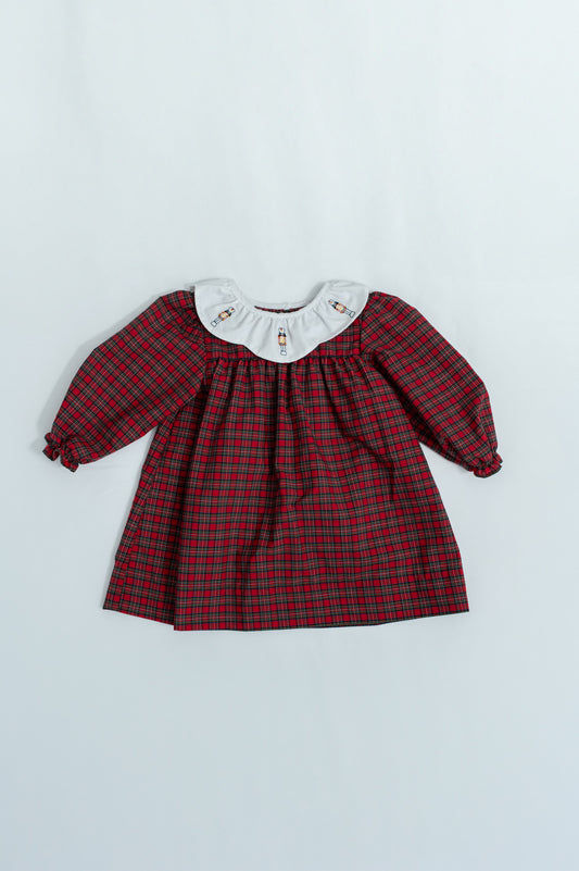 Red plaid dress with white collar on a light gray background