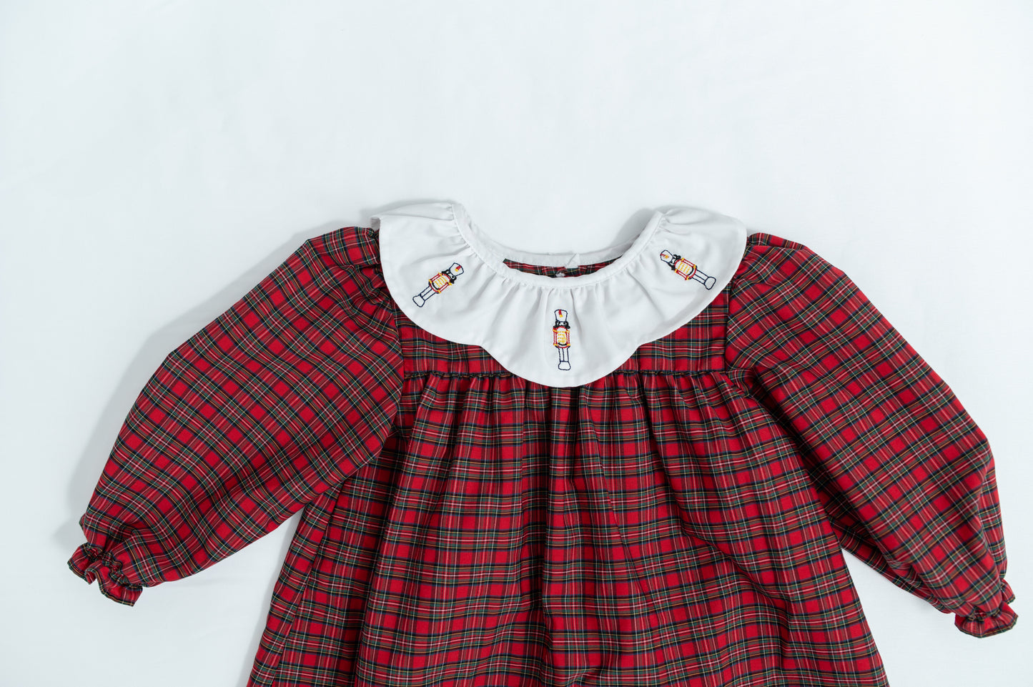 Red plaid dress with white collar on a light gray background