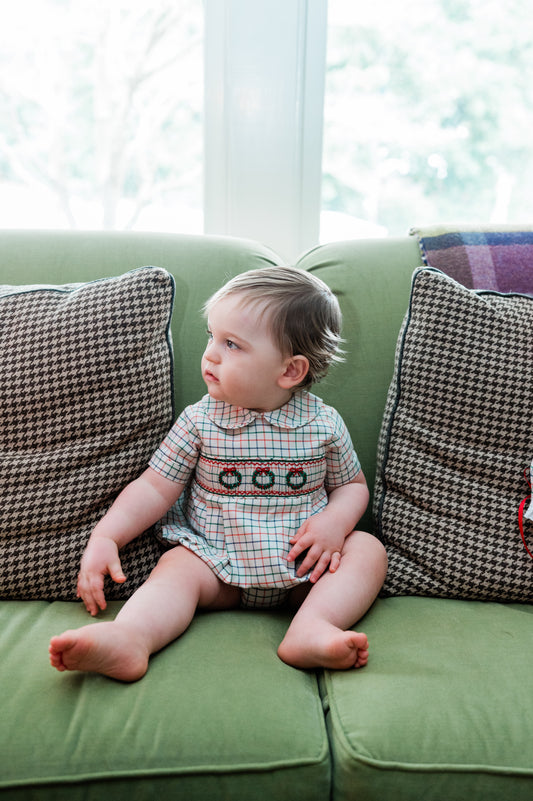 Child sitting on a green couch with patterned cushions