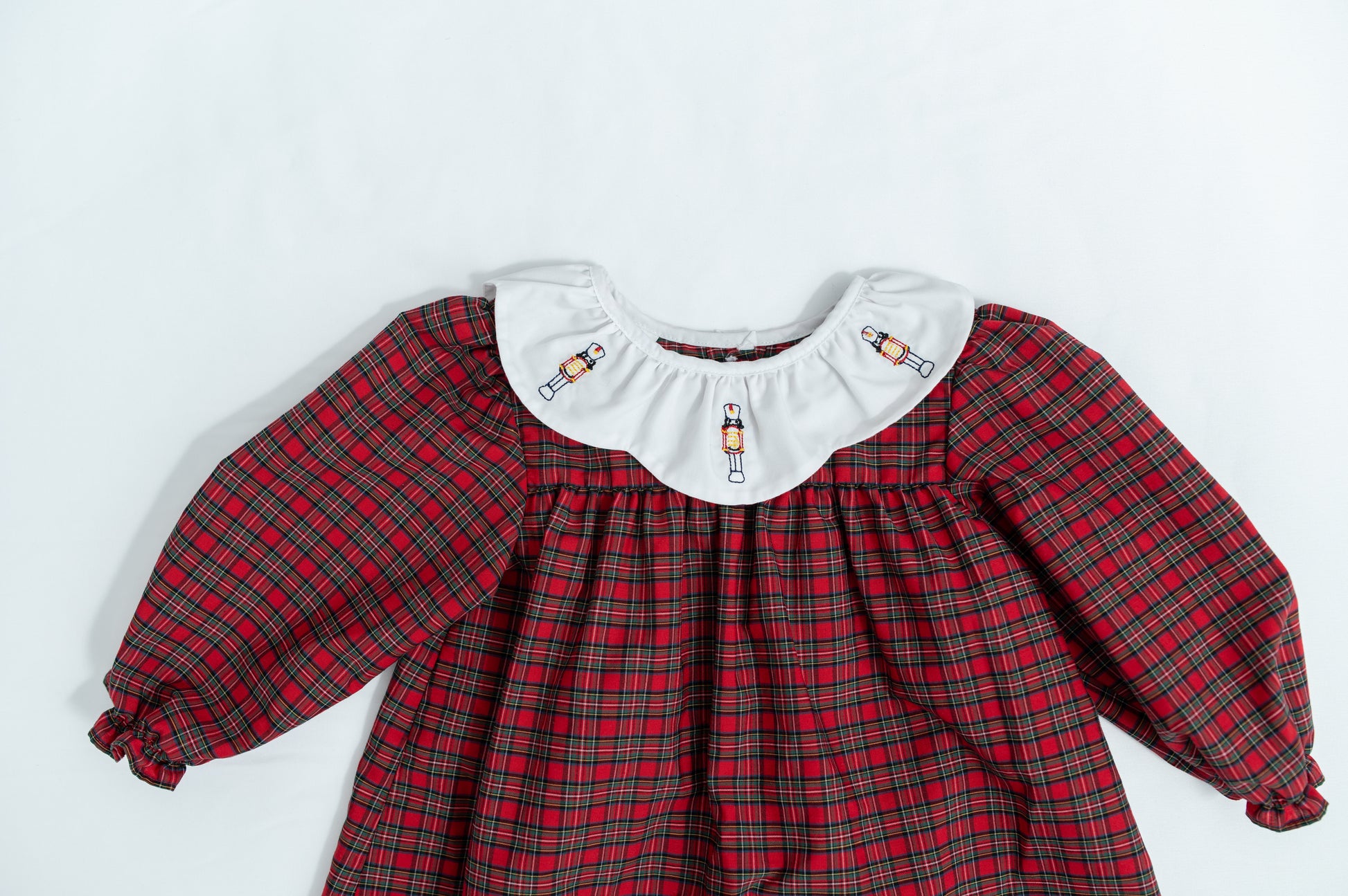 Red plaid dress with white collar on a light gray background